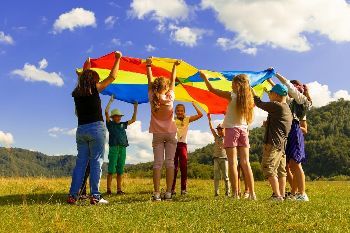 Children playing with a rainbow parachute